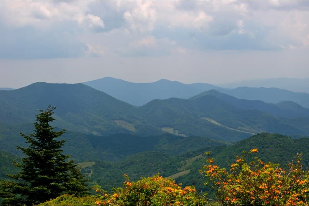 Lush green mountains stretch under a cloudy sky.